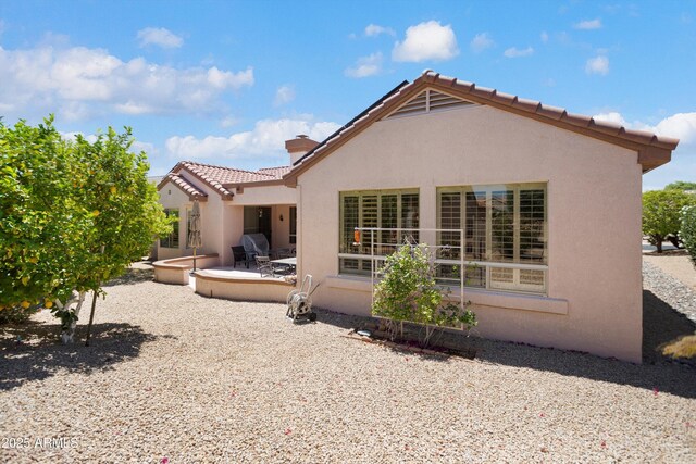 16158 W Copper Point Ln, Surprise, AZ 85374 - rear view of house featuring stucco siding, a patio area, a chimney, and a tiled roof