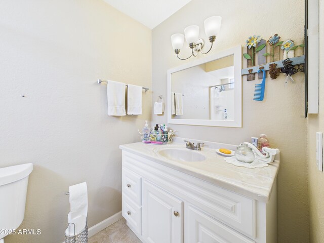 7676 W Sells Dr, Phoenix, AZ 85033 - full bath featuring vanity, tile patterned flooring, toilet, a chandelier, and baseboards