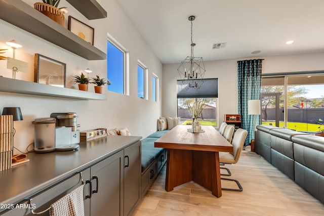 dining space featuring an inviting chandelier and light wood-type flooring