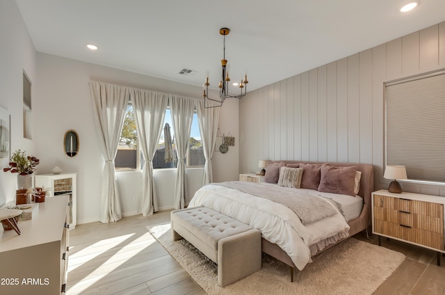 bedroom with hardwood / wood-style floors and a notable chandelier