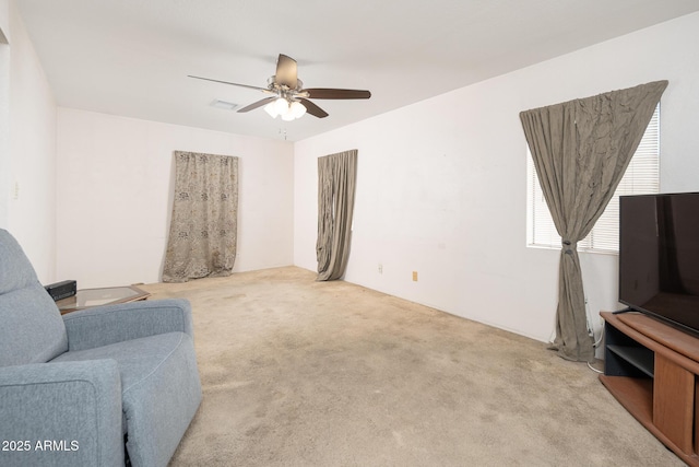 living area with light carpet, visible vents, and ceiling fan