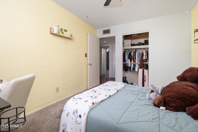 carpeted bedroom featuring visible vents, a ceiling fan, a textured ceiling, a closet, and baseboards