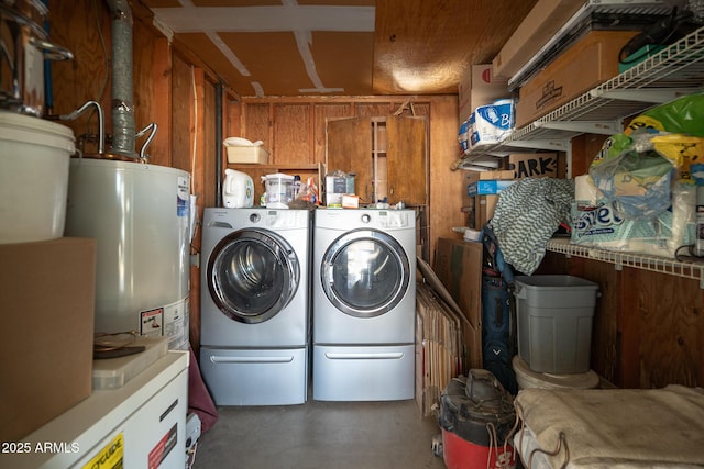 laundry room with laundry area, water heater, and washer and clothes dryer