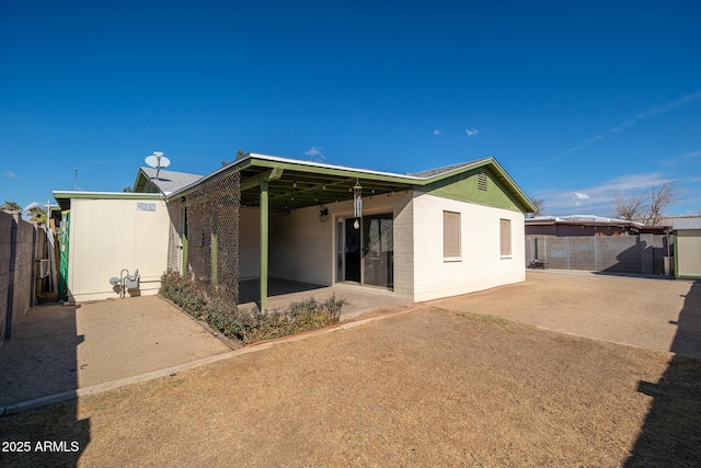 back of property featuring concrete block siding, a patio area, and a fenced backyard