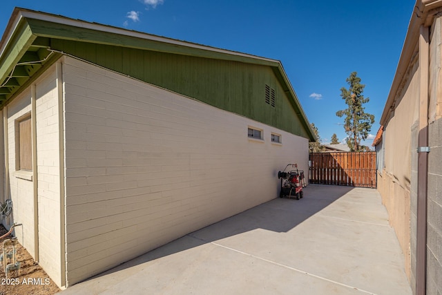 view of side of property featuring a patio area and fence