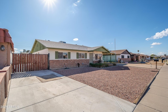 ranch-style house with brick siding and a gate