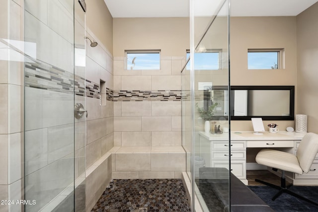 bathroom with a shower with shower door and vanity