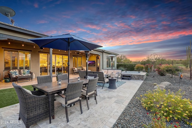 patio terrace at dusk featuring an outdoor living space with a fire pit