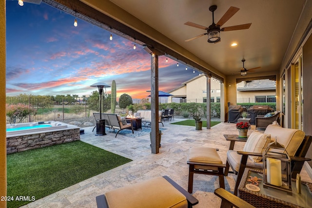 patio terrace at dusk featuring ceiling fan and an outdoor hangout area