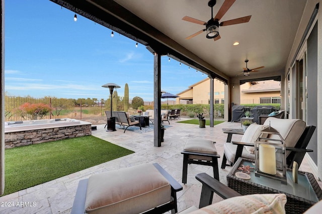 view of patio featuring ceiling fan, an outdoor living space, and a hot tub