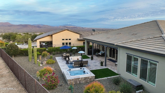 exterior space with a mountain view, a patio area, and an outdoor living space with a fire pit