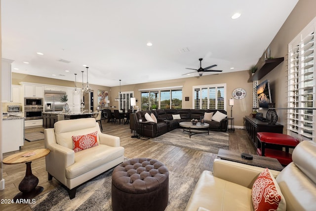 living room featuring ceiling fan and light wood-type flooring