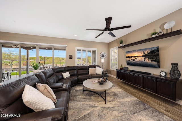 living room featuring dark wood-type flooring and ceiling fan