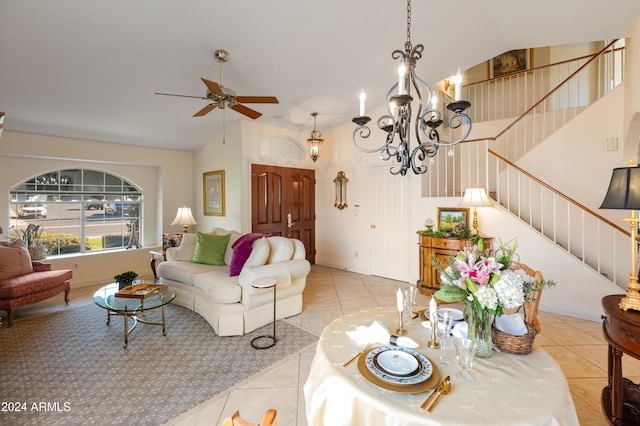 living room featuring light tile patterned floors, ceiling fan with notable chandelier, and lofted ceiling