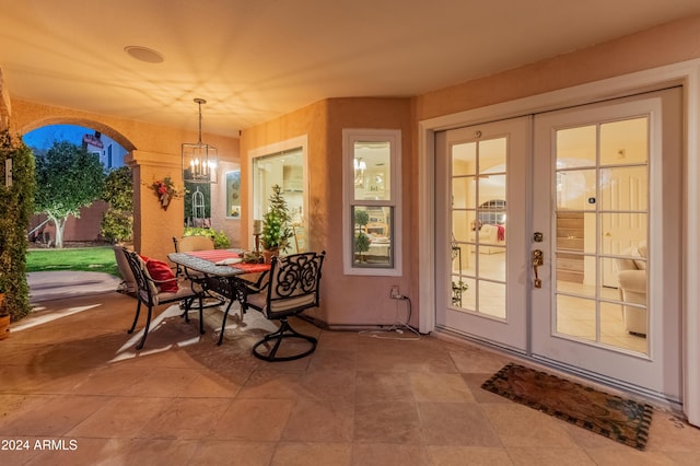 exterior space featuring french doors and a notable chandelier