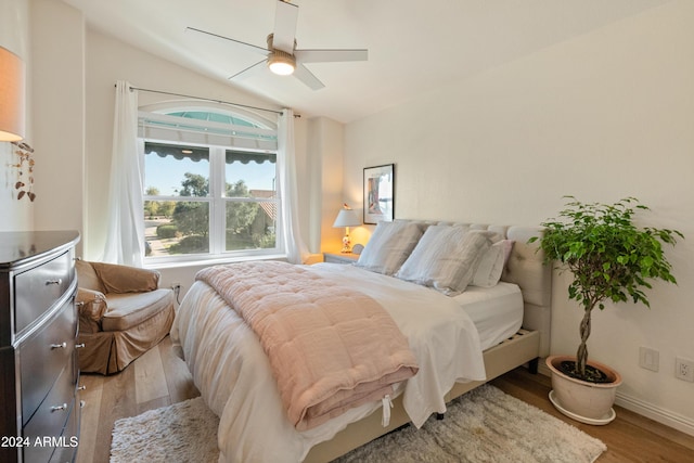 bedroom with light wood-type flooring, vaulted ceiling, and ceiling fan