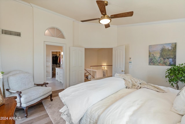 bedroom featuring light hardwood / wood-style flooring, ceiling fan, and ornamental molding