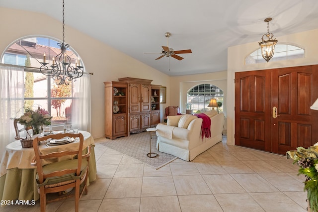 tiled living room with ceiling fan with notable chandelier and lofted ceiling