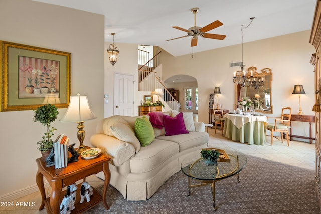 tiled living room featuring ceiling fan with notable chandelier and vaulted ceiling