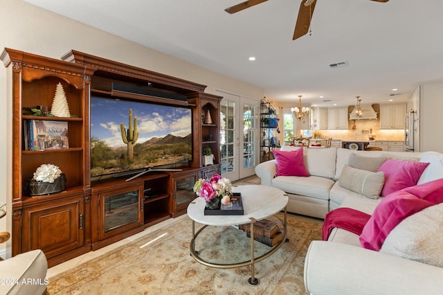 living room with french doors and ceiling fan with notable chandelier