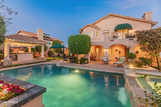 pool at dusk featuring a patio area