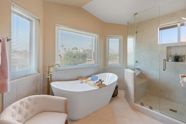 bathroom with plus walk in shower, lofted ceiling, tile walls, and a healthy amount of sunlight