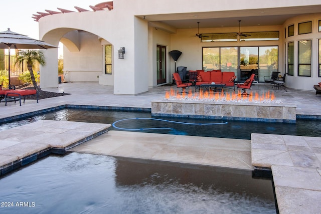 outdoor pool with a patio, an outdoor living space with a fire pit, and a ceiling fan