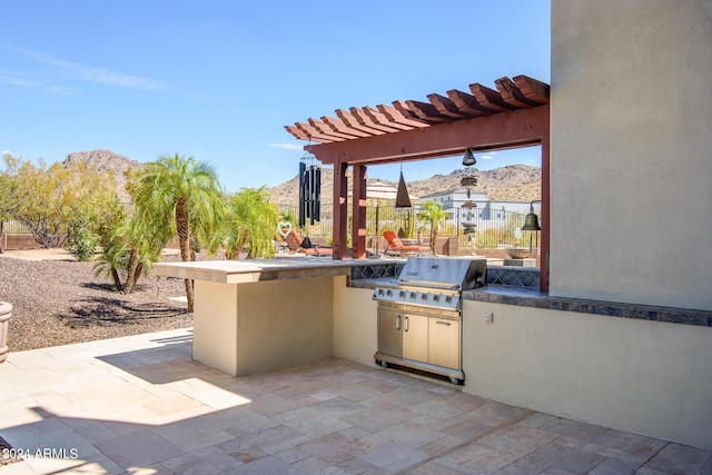 view of patio / terrace featuring area for grilling, grilling area, fence, a mountain view, and a pergola