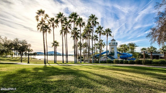 view of jungle gym featuring a lawn and a water view