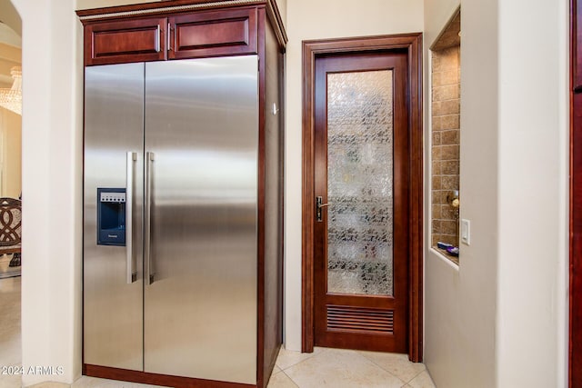 kitchen featuring high quality fridge, dark brown cabinets, and light tile patterned floors