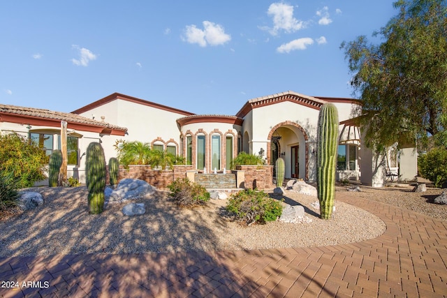 view of front facade with a tiled roof and stucco siding