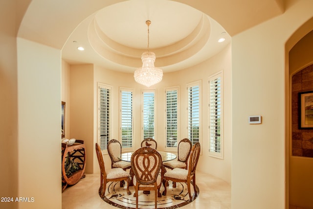 tiled dining area with a raised ceiling and an inviting chandelier