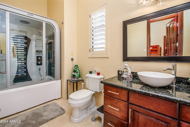 full bathroom featuring tile patterned flooring, shower / bath combination with glass door, vanity, and toilet