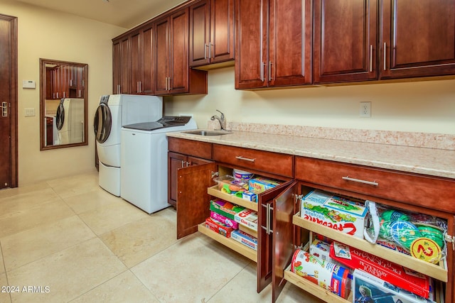 laundry room with light tile patterned floors, cabinet space, a sink, and separate washer and dryer