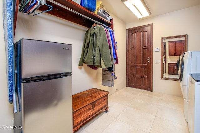 mudroom with light tile patterned floors and washing machine and dryer