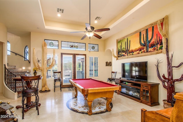 rec room featuring a tray ceiling, french doors, visible vents, and arched walkways