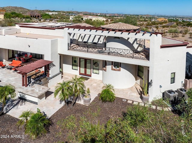 rear view of property with a patio, a balcony, central air condition unit, french doors, and stucco siding