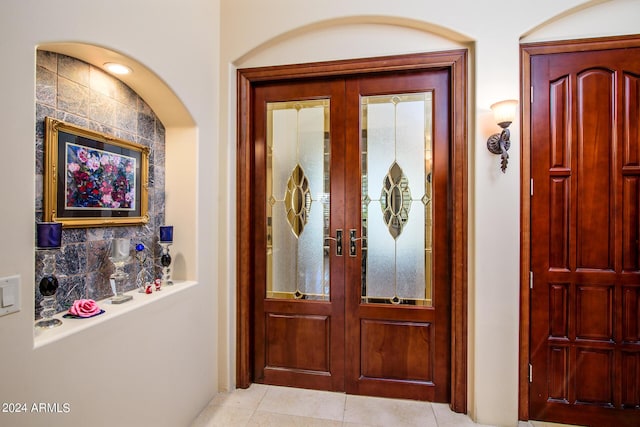 foyer entrance featuring light tile patterned floors and french doors