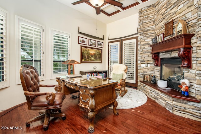 office featuring baseboards, a ceiling fan, wood finished floors, and a stone fireplace