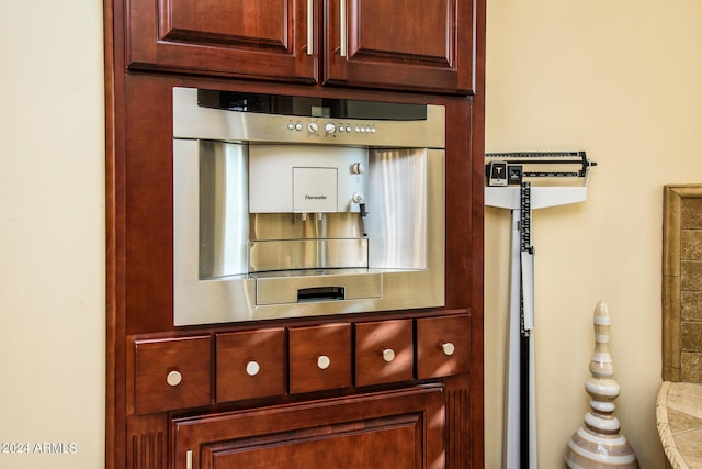 details featuring reddish brown cabinets, stainless steel oven, and light countertops