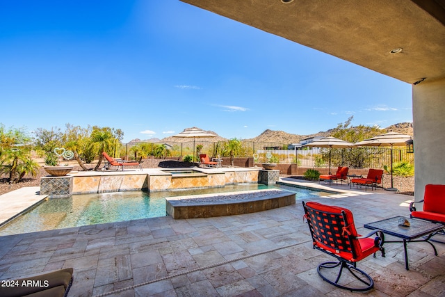 view of swimming pool featuring an in ground hot tub, pool water feature, and a patio area