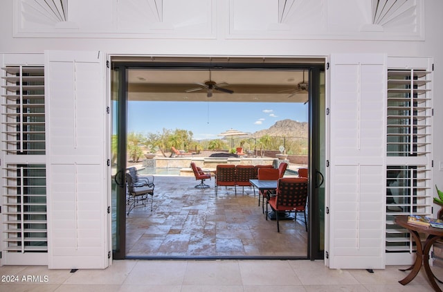 doorway to outside featuring a ceiling fan and a mountain view