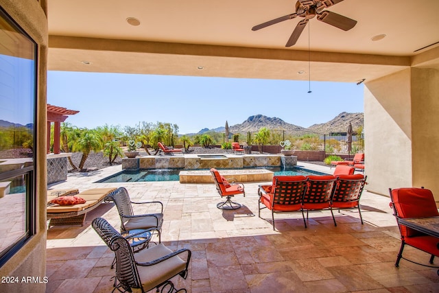 view of patio / terrace featuring ceiling fan, a fenced backyard, a mountain view, and a fenced in pool