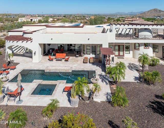 rear view of house featuring an outdoor pool, a patio area, a mountain view, an outdoor living space, and stucco siding