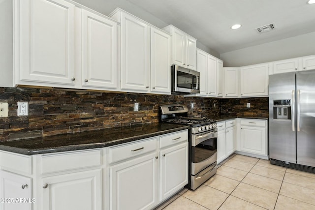 kitchen featuring white cabinetry, tasteful backsplash, light tile patterned flooring, and appliances with stainless steel finishes