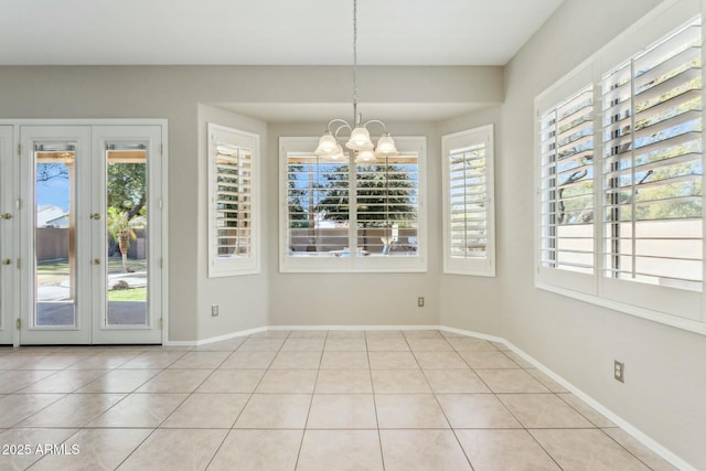 unfurnished dining area featuring an inviting chandelier, plenty of natural light, and light tile patterned flooring