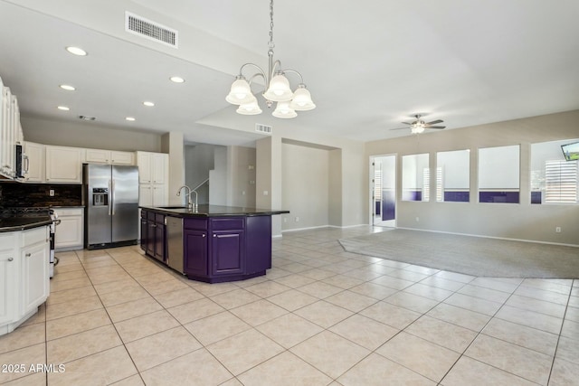 kitchen featuring sink, light tile patterned floors, appliances with stainless steel finishes, an island with sink, and white cabinets