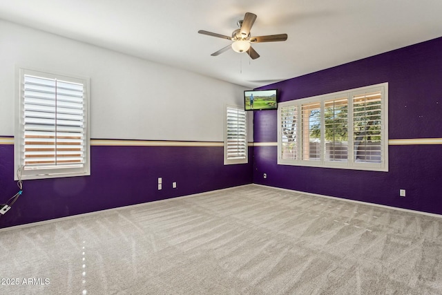 carpeted spare room with a wealth of natural light and ceiling fan