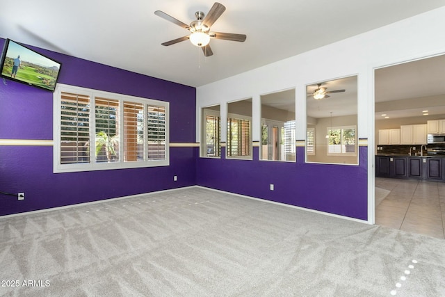 spare room featuring light carpet and ceiling fan