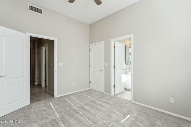 unfurnished bedroom featuring ensuite bathroom, light carpet, and ceiling fan